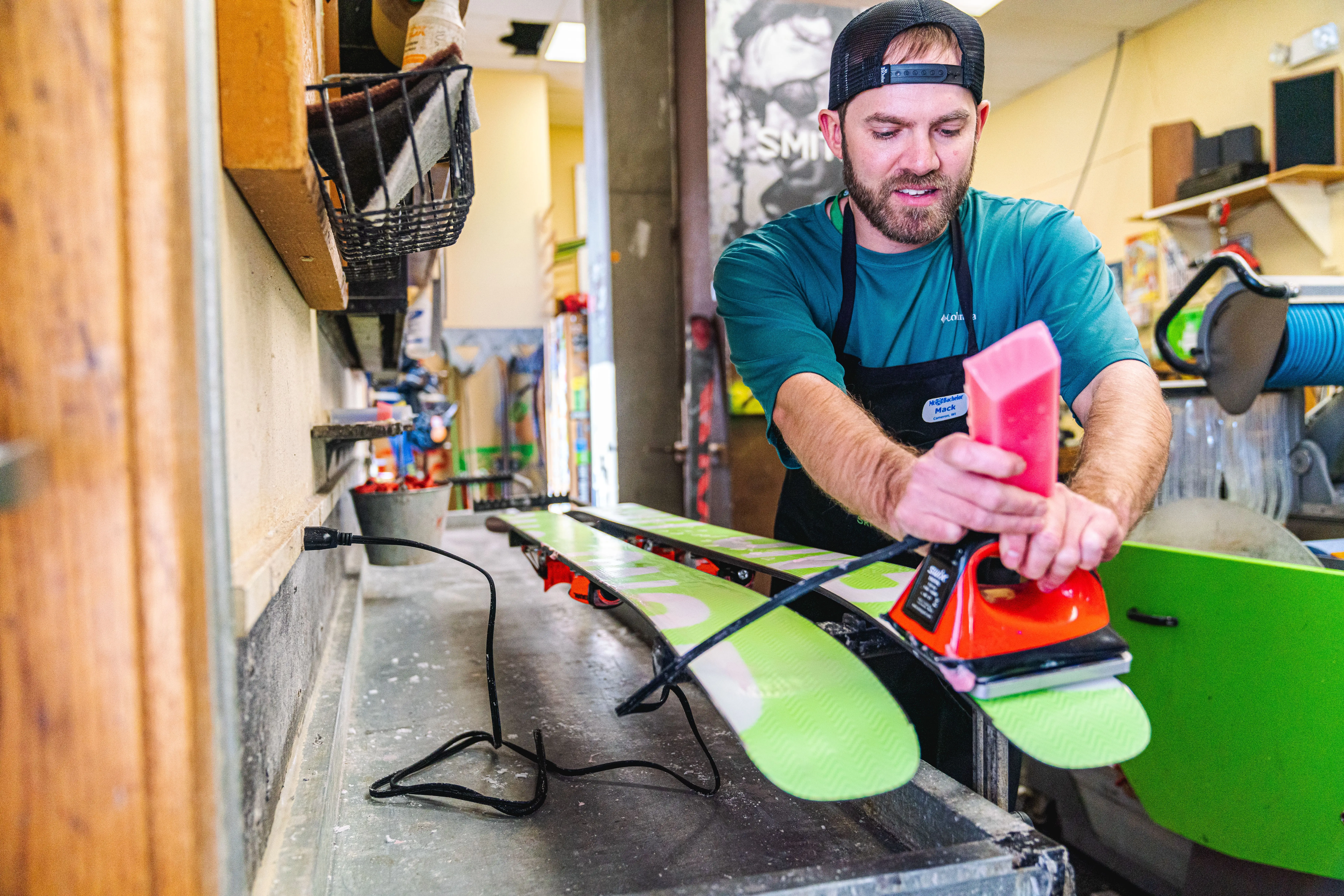 Mt. Bachelor technician expertly hot waxing skis in preparation for a smooth and optimal downhill experience on the slopes.