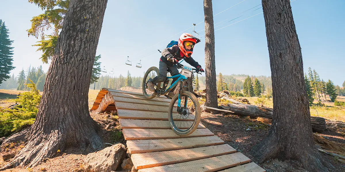 Child mountain biker on Mt. Bachelor Bike Park trail during Kids Summer Bike Camp in Bend, Oregon