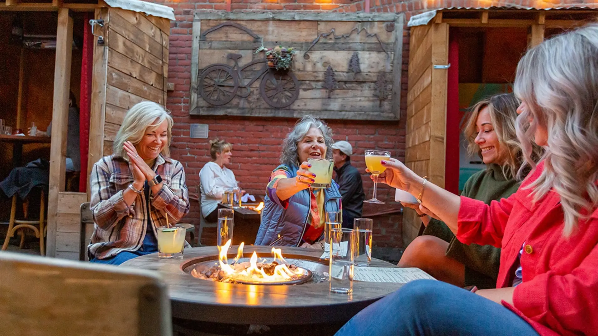 Women enjoying drinks by a fire pit in Bend, OR